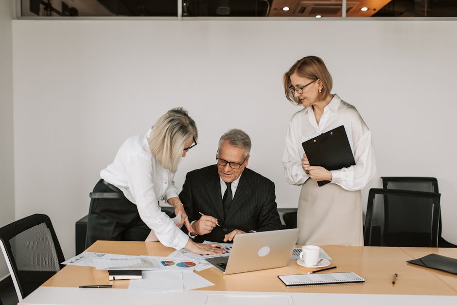 Elderly man and two women collaborating in a modern office setting